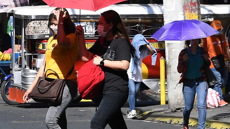 Des personnes marchent avec des parapluies pendant une vague de chaleur à Manille (Philippines), le 29 avril 2024.