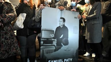 Des proches et des collègues tiennent une photo de Samuel Paty, professeur assassiné en 2020 par un jeune jihadiste, le 20 octobre 2020 à Conflans-Sainte-Honorine 