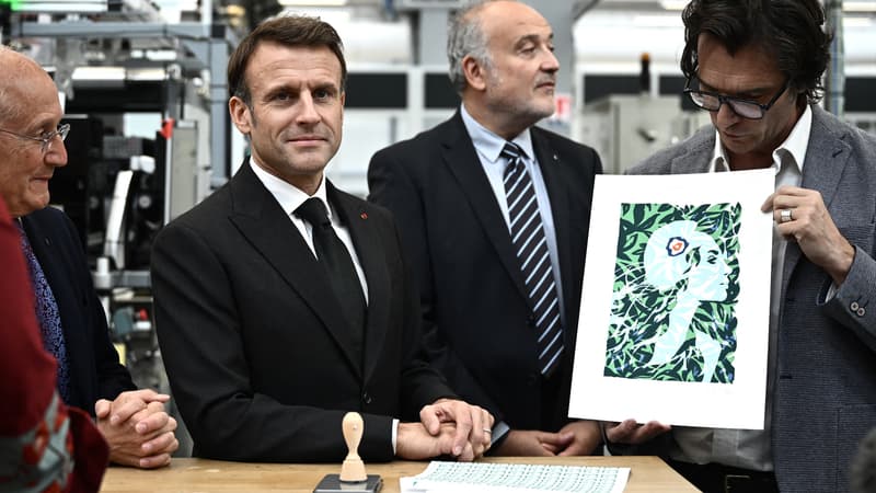Le président français Emmanuel Macron, flanqué du PDG du groupe "La Poste" Philippe Wahl (à gauche) et du président de Philaposte Paul Dworkin (au centre), est présenté par l'illustrateur français Olivier Balez (à droite) le nouveau visage de Marianne qui sera représenté sur les timbres français de La Poste à l'imprimerie nationale de timbres Philaposte lors d'une cérémonie de dévoilement à Boulazac, dans le sud-ouest de la France, le 7 novembre 2023.