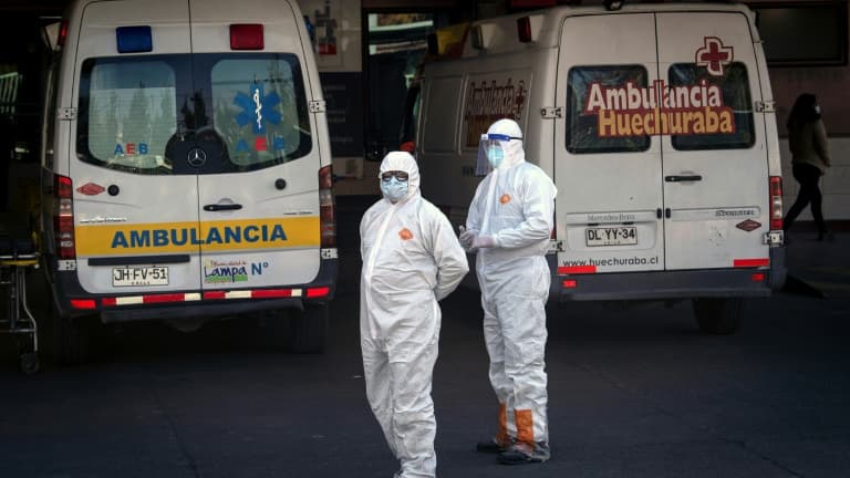 Des personnels soignants attendent près d'une ambulance transportant une personne atteinte par le coronavirus, le 5 juin 2020 à Santiago du Chili