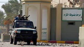 Rebelles libyens à l'entrée sud de la caserne Bab Al Aziziah, quartier général de Mouammar Kadhafi à Tripoli, pris d'assaut et pillé. Le Conseil national de transition (CNT) formé à Benghazi par les rebelles libyens a promis mercredi une récompense de 1,3