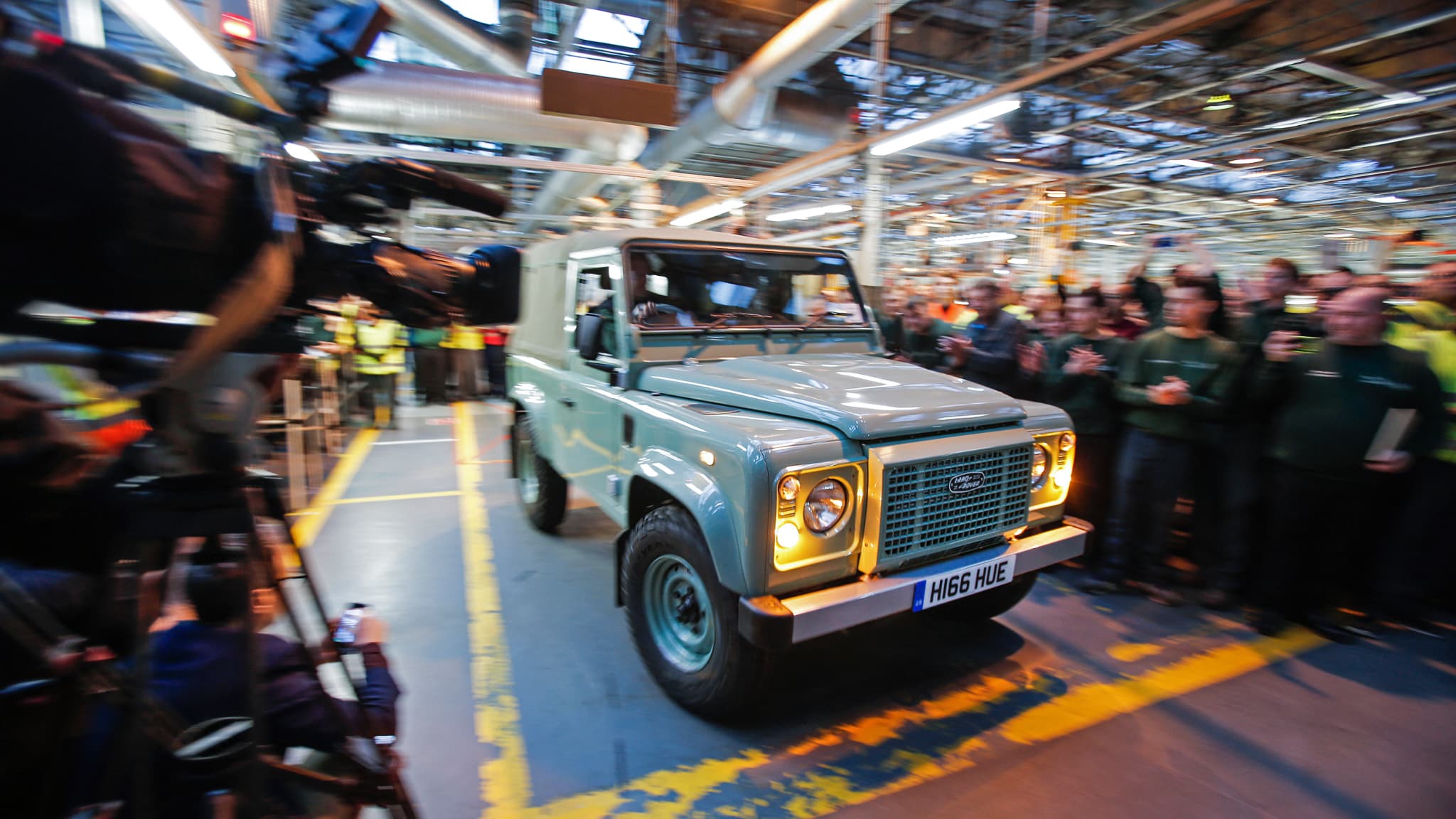 A handout photo taken on January 29, 2016, in Solihull, central England, shows the last-ever Land Rover Defender vehicle to be produced by Jaguar Land Rover, as it is driven off of the production line. The last-ever Land Rover Defender, a vehicle beloved by Queen Elizabeth II and featured in Hollywood blockbusters, rolled off the production line in Britain today. Indian-owned carmaker Jaguar Land Rover had already announced in late 2013 that the group would stop making the legendary Defender at its car plant in Solihull in the West Midlands in central England.
