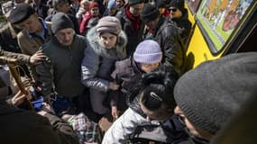 Des habitants montent dans un bus pour rejoindre la gare à Severodonetsk, le 7 avril 2022 dans la région du Donbass, dans l'est de l'Ukraine