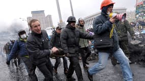 Des opposants évacuent un blessé de la place Maïdan, jeudi 20 février, à Kiev.