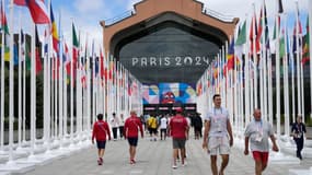 Les participants aux Jeux Olympiques et Paralympiques de Paris 2024 marchent devant la cafétéria du Village Olympique, à Saint-Denis, le 22 juillet 2024.