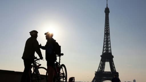 Deux cyclistes discutent devant la tour Eiffel avant de participer à la "journée sans voiture" organisée par la mairie de Paris, le 27 septembre 2015