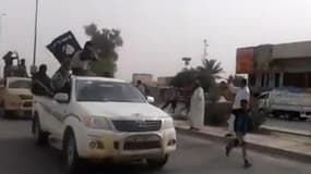 Image tirée d'une vidéo visible sur Youtube visible le 17 juin 2014, montrant des hommes armés tenant un drapeau de l'EI dans la ville de Baïji en Irak
