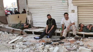 Des soldats de l'armée syrienne se reposent dans la partie contrôlée de la ville assiégée de Daraya, le 26 août 2016. Pendant ce temps, des milliers de rebelles et leurs familles se préparent à évacuer la ville.