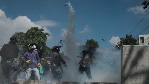 Les manifestants anti-gouvernement renvoient du gaz lacrymogène aux forces de l'ordre à Bangkok en Thaïlande le 1er décembre 2013.