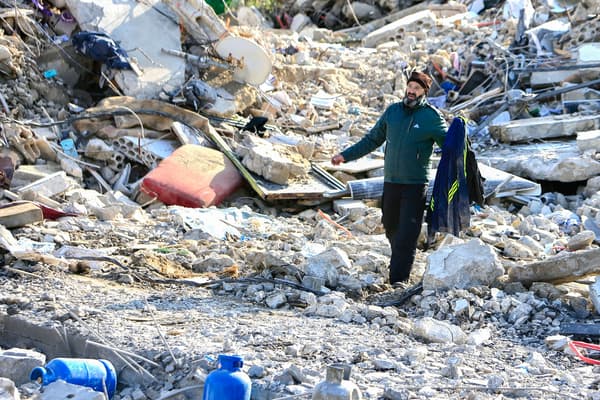 Un homme récupère des vêtements dans les décombres d'un bâtiment à Bint Jbeil dans le sud du Liban, le 27 décembre 2023.