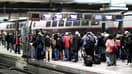 Des voyageurs patientent sur un quai de la gare Montparnasse avant d'embarquer dans un train, à Paris le 2 décembre 2022 (illustration)