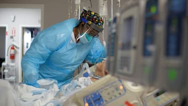 Une soignante au chevet d'un patient dans un département des malades du Covid-19.