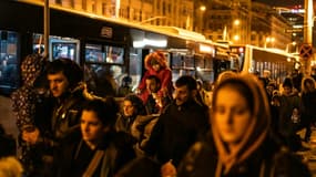 Des réfugiés d'Ukraine montent dans des bus après leur arrivée à la gare de Bucarest, le 4 mars 2022 en Roumanie