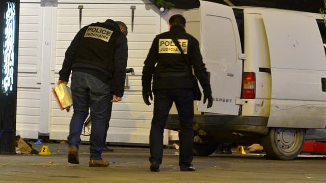 Des policiers inspectent la camionnette blanche qui s'est encastrée dans un chalet du marché de Noël, place Royale à Nantes, lundi.