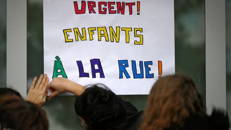 Des enseignants et des bénévoles du DAL (Droit au logement) accrochent une pancarte indiquant "Urgent ! Enfants à la rue" devant l'école primaire Sylvain Dauriac pour alerter sur les conditions de vie de certaines familles dont les enfants fréquentent cette école, à Toulouse, dans le sud-ouest de la France, le 8 décembre 2021. Depuis début décembre 2021, des familles, dont 23 enfants, occupent le gymnase Saint Sernin, à Toulouse. Des associations dont le DAL et des enseignants ont décidé de se mobiliser pour mettre fin à cette situation précaire.