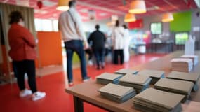 Des électeurs attendent pour voter dans un bureau de vote.