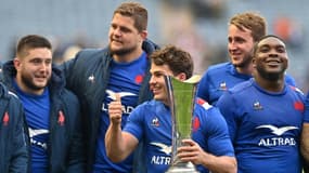 Antoine Dupont, capitaine et demi de mêlée du XV de France, tient en main le trophée de l'Auld Alliance au milieu de partenaires après la victoire 36-17 face à l'Ecosse le samedi 26 février 2022 à Edimbourg.
