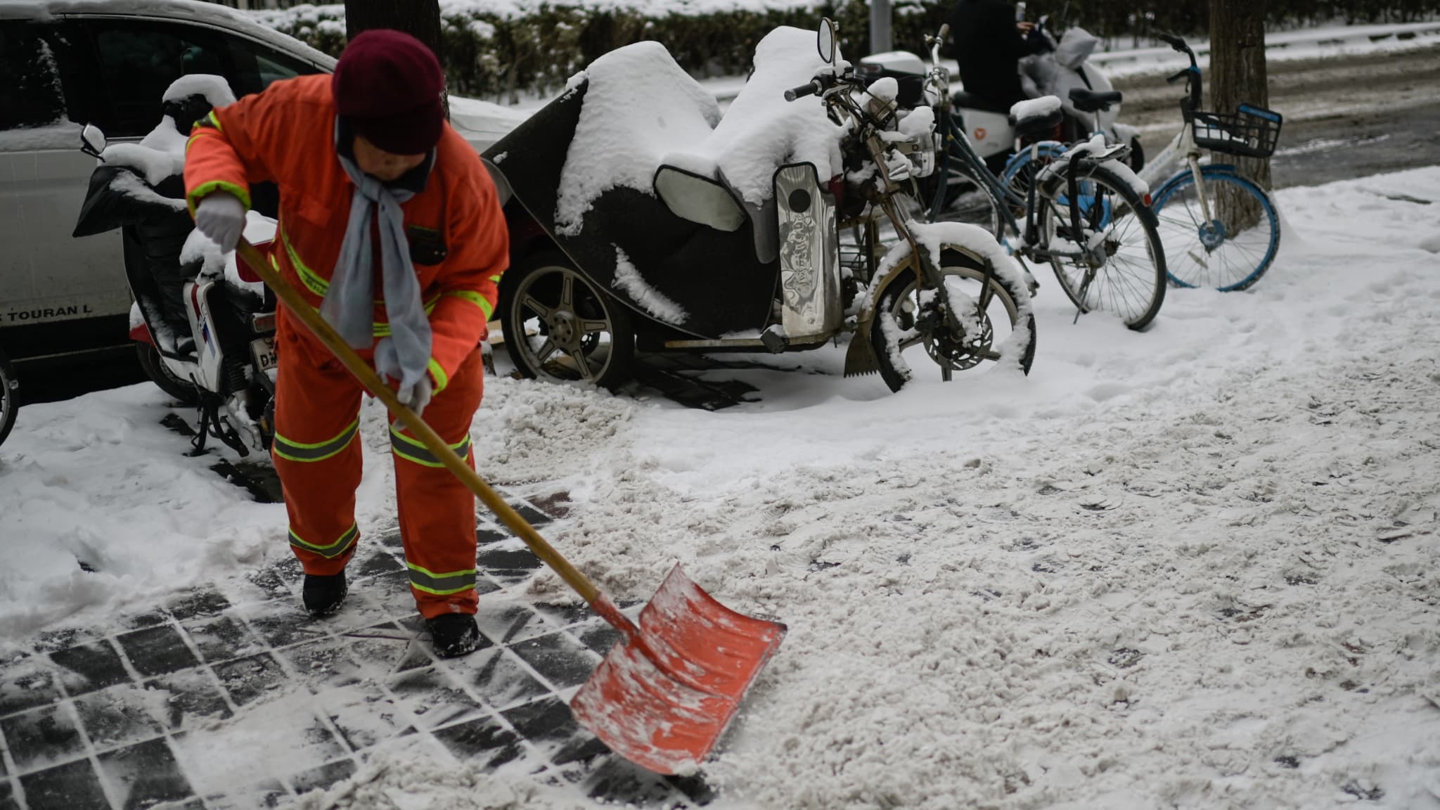 Un ouvrier déneige une rue de Pékin le 21 février 2024.
