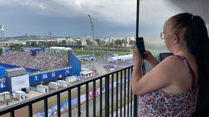 Une habitante de Colombes (Hauts-de-Seine) sur son balcon fin juillet 2024, face au stade Yves-du-Manoir qui accueille les épreuves olympiques de hockey sur gazon.