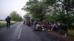 Des demandeurs d'asile assis sur une route à la frontière entre la Serbie et la Hongrie (illustration)