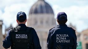 Deux policiers locaux italiens devant la basilique Saint-Pierre du Vatican en arrière-plan, à Rome, le 24 avril 2025