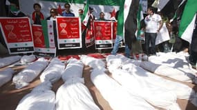 Des suaires, symbolisant les corps de manifestants tués en Syrie, sont placés à terre non loin du siège de la Ligue arabe au Caire. La Syrie ne participera pas à la réunion de la Ligue arabe, ce mercredi à Rabat (Maroc), qui doit entériner la décision de