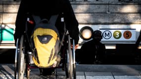 Une personne en fauteuil roulant au sommet des marches d'une station de métro parisienne le 26 septembre 2018, durant une démonstration de l'Association des paralysés de France afin de protester contre le manque d'accessibilité des transports en commun à Paris.