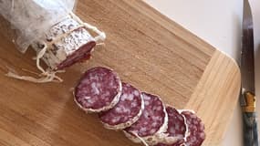 Un saucisson tranché en rondelles sur une planche à découper (photo d'illustration).