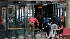 Des employés d'un café à Paris préparent la terrasse le 10 mai 2021
