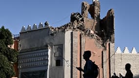 Des personnes passent devant un bâtiment endommagé par le séisme deux jours après à Marrakech, le 10 septembre 2023