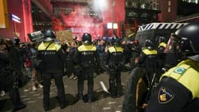 Des policiers anti-émeute font face à des manifestants à La Haye, aux Pays-Bas, après l'annonce de nouvelles restrictions sanitaires, le 12 novembre 2021