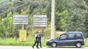 Des gendarmes à un carrefour près du village Les Plantiers dans les Cévennes, le 11 mai 2021 à la recherche d'un homme qui a tué son patron et un collègue