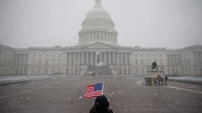 Un drapeau américain flotte dans la neige à l'extérieur du Capitole des États-Unis, le 19 janvier 2025 à Washington, DC. Le président élu des États-Unis Donald Trump et le vice-président élu JD Vance prêteront serment le 20 janvier. (Photo d'illustration)