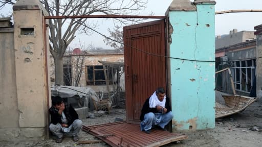 Des Afghans devant leur maison détruite à Kaboul, le 2 janvier 2016 conséquence de l'attentat contre le restaurant français