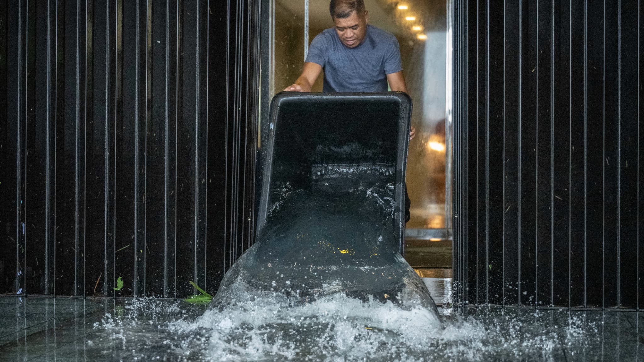 Un membre du personnel évacue l'eau d'un bâtiment lors des fortes pluies provoquées par le super-typhon Bavi. Un membre du personnel évacue l'eau d'un bâtiment lors des fortes pluies provoquées par le super-typhon Bavi.