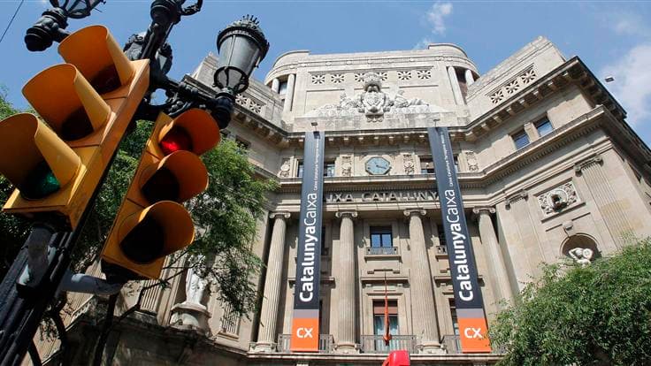 Devant le siège de la banque Catalunya Caixa, à Barcelone. L'Espagne demandera une aide à ses partenaires européens pour recapitaliser ses banques mais Madrid attend les résultats d'audits afin d'avoir une idée plus claire des besoins de ses établissement