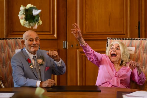 Jeanne Swerlin, 96 ans, (à droite) jette son bouquet de fleurs après avoir officialisé son mariage avec Harold Terens, 100 ans, vétéran américain de la Seconde Guerre mondiale.