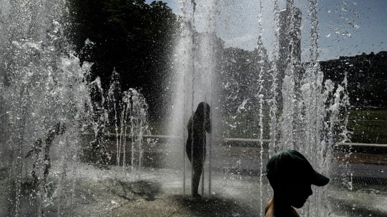 Des enfantts se rafraîchissent sous les jets d'eau d'une fontaine à Lyon, le 25 juin 2025 