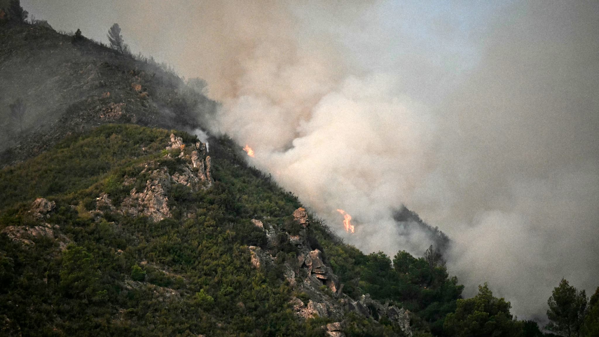 La fumée et les flammes s'élevant d'un incendie de forêt près de Fontjoncouse, dans l'Aude, le 6 août 2025. La fumée et les flammes s'élevant d'un incendie de forêt près de Fontjoncouse, dans l'Aude, le 6 août 2025.