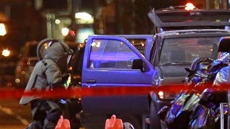 Policier inspectant le véhicule suspect à Times Square. Le secteur de Times Square, à Manhattan en plein New York, a été évacué par la police samedi soir en raison de la présence de ce qui a tout l'air d'être un véhicule piégé, selon le département de pol