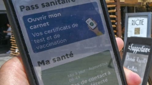 Un homme montre un pass sanitaire sur une terrasse de restaurant à Montpellier le 11 août 2021