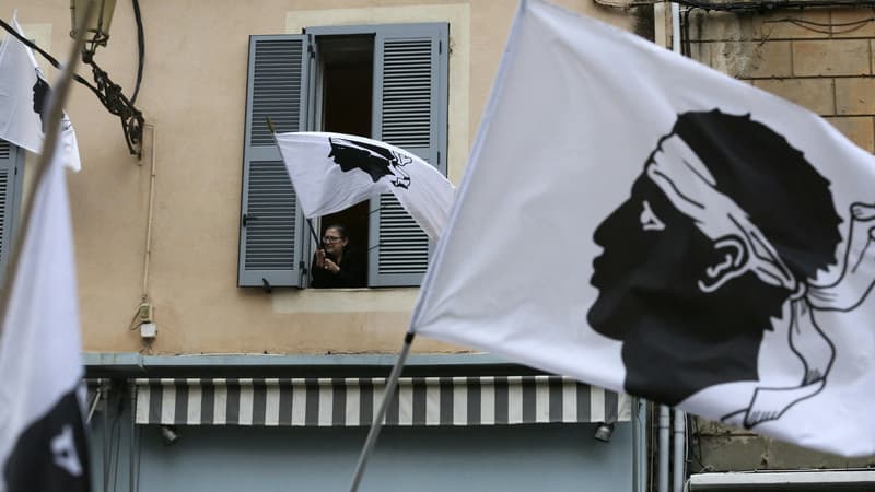 Une femme agite un drapeau corse en marge d'une manifestation pour Yvan Colonna à Bastia le 13 mars 2022. 