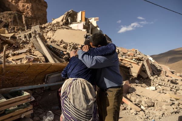 Des membres d'une famille près des décombres de bâtiments effondrés dans le village d'Imi N'Tala près d'Amizmiz, au Maroc, après le séisme meurtrier de magnitude, le 10 septembre 2023.