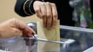 Une électrice glisse son bulletin dans une urne du Touquet pour le premier tour des législatives, le 12 juin 2022
