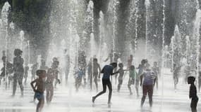Des personnes s'amusent dans une fontaine de Nice, le 31 juillet 2018.
