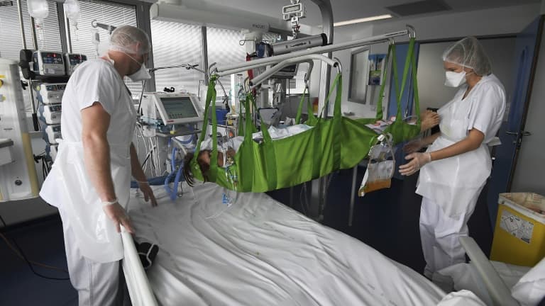 Des soignants prennent en charge un patient atteint du Covid-19 dans l'unité de soins intensifs de l'hôpital universitaire de Strasbourg, le 22 octobre 2020