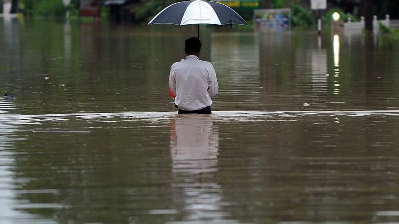 Un Sri Lankais patauge dans l'eau à Pugoda, le 16 mai 2016.