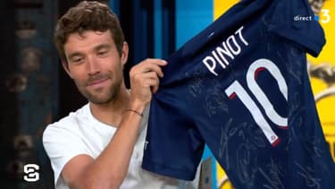 Thibaut Pinot montre son maillot dédicacé du PSG sur le plateau de Stade 2