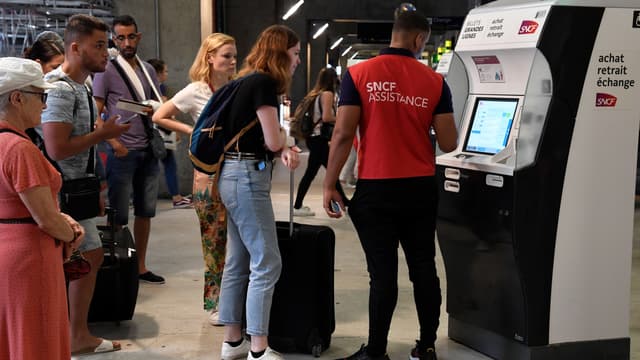 Un agent de la SNCF aide des voyageurs dans la gare Montparnasse, le 28 juillet 2018, alors que la circulation est fortement perturbée par une panne électrique.