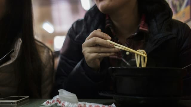 Une femme mange des nouilles dans un restaurant de Pékin (Chine) le 19 novembre 2014.